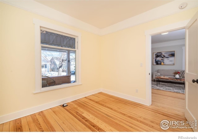 spare room featuring hardwood / wood-style flooring and ornamental molding