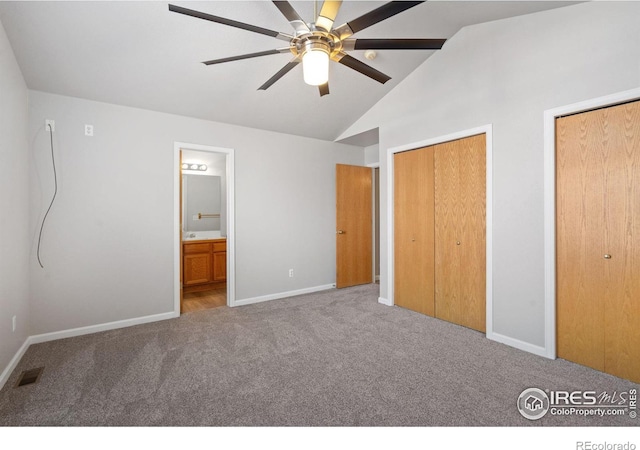 unfurnished bedroom featuring light carpet, ensuite bath, lofted ceiling, and ceiling fan