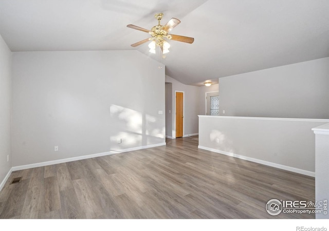 unfurnished room featuring hardwood / wood-style flooring, ceiling fan, and vaulted ceiling