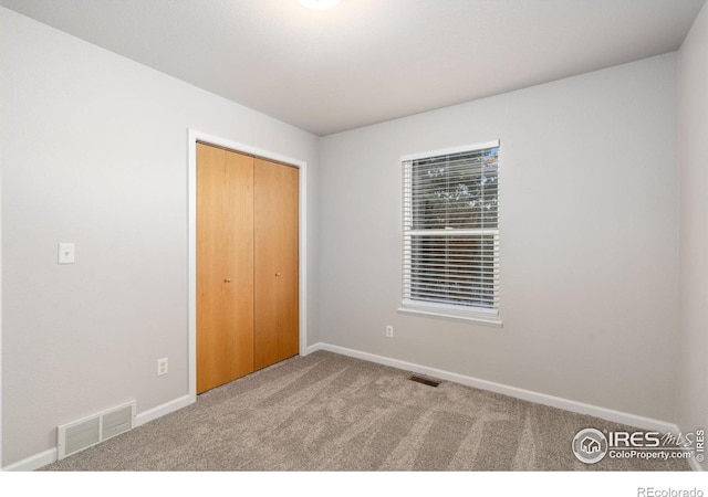 unfurnished bedroom with a closet and carpet flooring