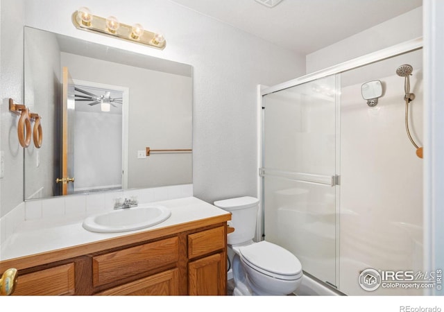 bathroom featuring vanity, toilet, and a shower with door