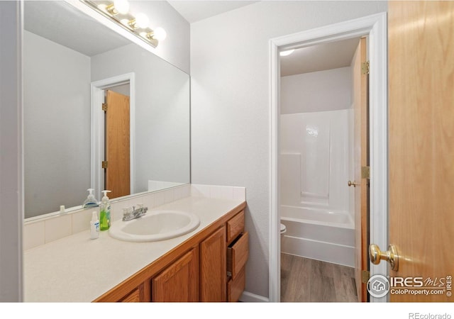 bathroom featuring shower / tub combination, vanity, and hardwood / wood-style floors