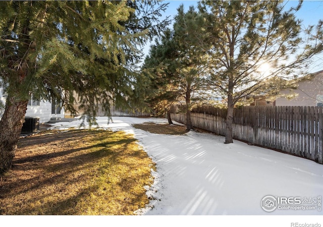 yard layered in snow featuring central AC unit