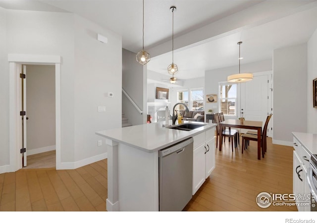 kitchen with an island with sink, sink, white cabinets, hanging light fixtures, and stainless steel dishwasher