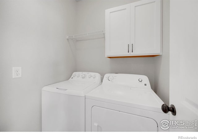 washroom featuring cabinets and separate washer and dryer