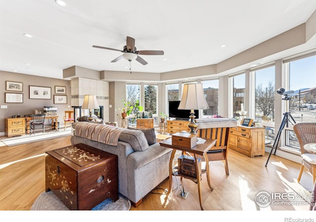 living room featuring ceiling fan, a wealth of natural light, and light wood-type flooring