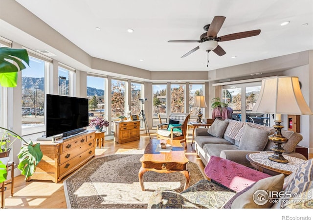 living room featuring light hardwood / wood-style floors and ceiling fan