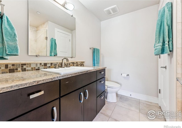 bathroom with walk in shower, tile patterned floors, toilet, vanity, and decorative backsplash