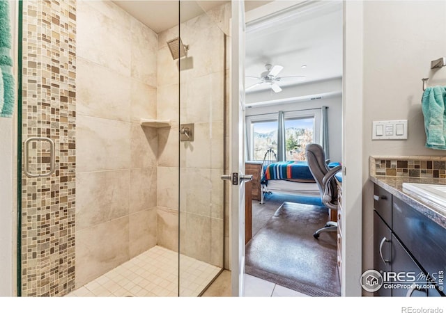 bathroom with vanity, ceiling fan, an enclosed shower, and backsplash