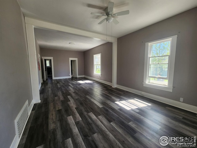 spare room featuring dark wood-type flooring, a wealth of natural light, and ceiling fan