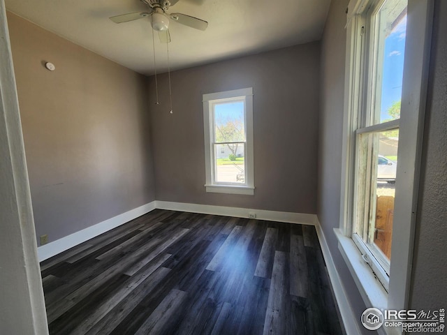 empty room with ceiling fan and dark hardwood / wood-style flooring