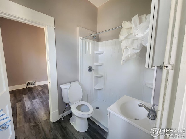 bathroom featuring sink, hardwood / wood-style flooring, toilet, and walk in shower