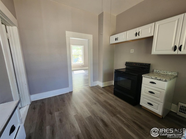 kitchen featuring light stone countertops, black electric range, white cabinets, and dark hardwood / wood-style flooring