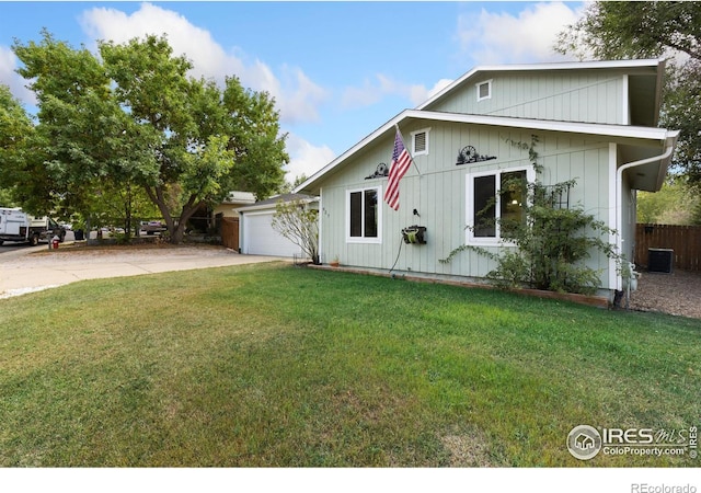 view of front of home featuring cooling unit, a garage, and a front lawn