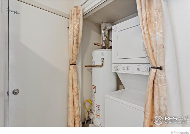 clothes washing area featuring stacked washing maching and dryer and gas water heater