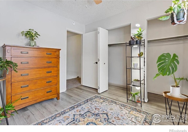 bedroom with light hardwood / wood-style flooring, a closet, and a textured ceiling