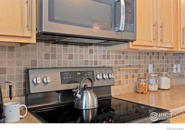 details with decorative backsplash, appliances with stainless steel finishes, light brown cabinetry, and light countertops