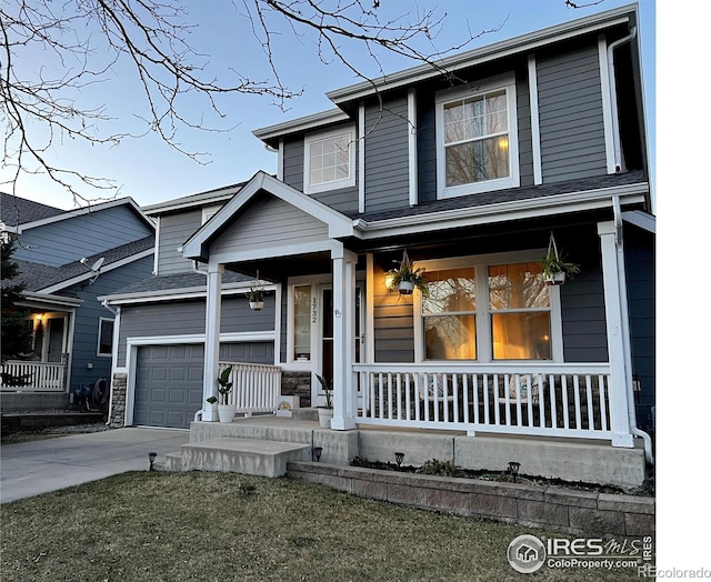 view of front of home featuring a garage, covered porch, and driveway