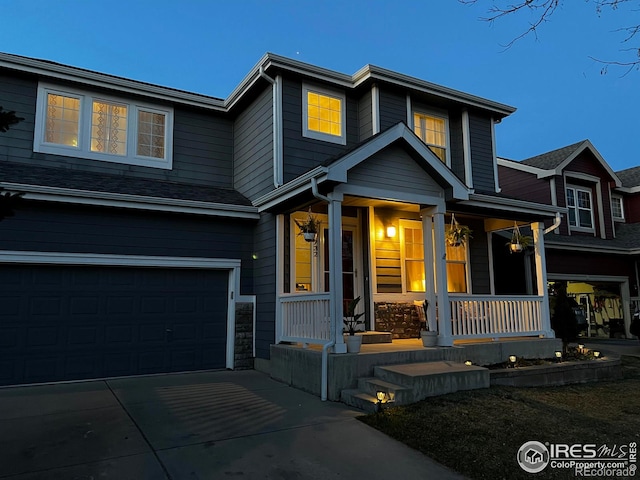 view of front of home featuring a porch, an attached garage, and driveway