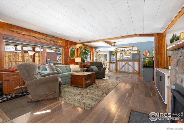 living room with wooden walls, dark hardwood / wood-style floors, and a fireplace