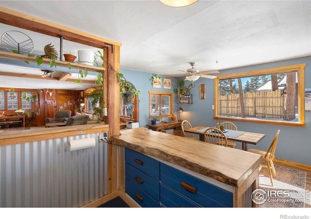 kitchen featuring blue cabinetry, a peninsula, and a ceiling fan