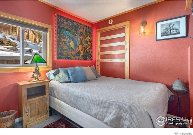 carpeted bedroom featuring a textured wall