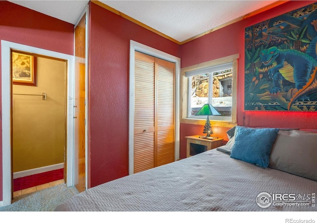 bedroom with a textured ceiling and a closet