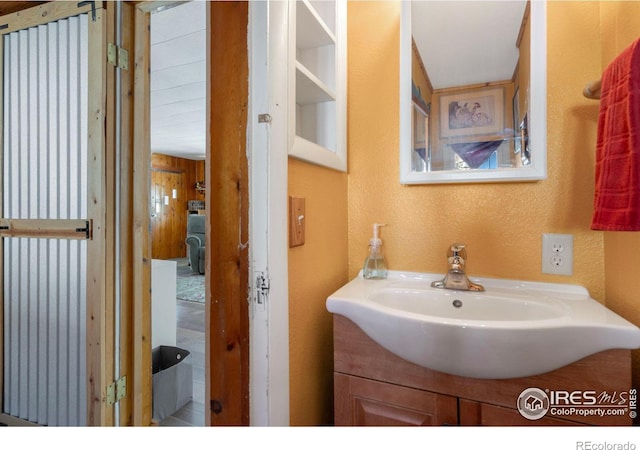 bathroom featuring vanity and a textured wall