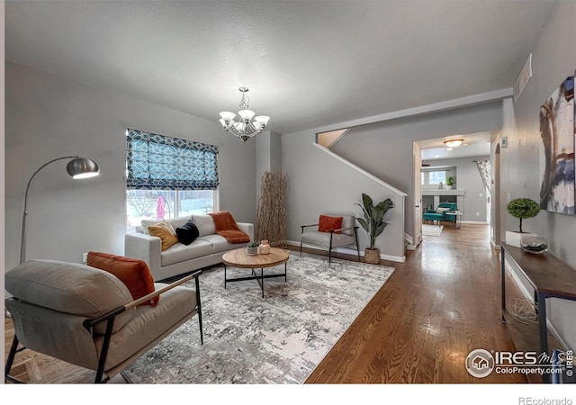 living room with hardwood / wood-style floors and a notable chandelier