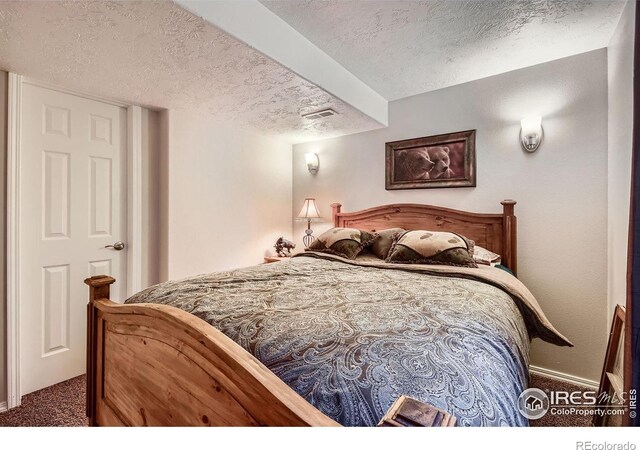 bedroom with carpet floors and a textured ceiling