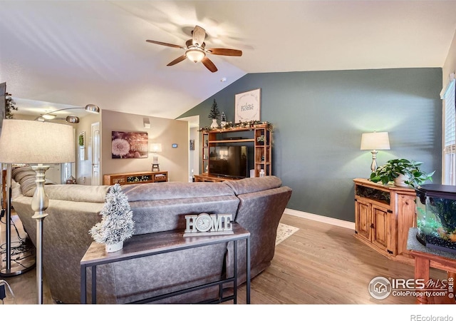 living room featuring vaulted ceiling, ceiling fan, and light hardwood / wood-style flooring