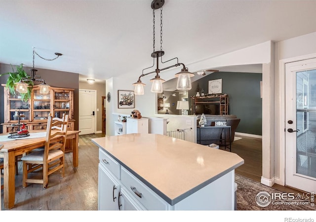 kitchen with white cabinetry, a kitchen island, dark wood-type flooring, and hanging light fixtures