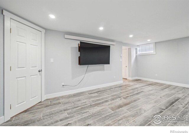 basement with light hardwood / wood-style flooring