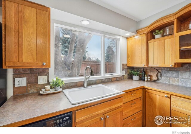 kitchen featuring sink, backsplash, and black dishwasher