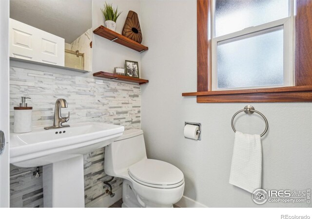 bathroom featuring toilet and decorative backsplash