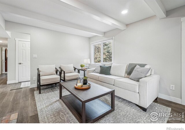 living room with dark wood-type flooring and beamed ceiling