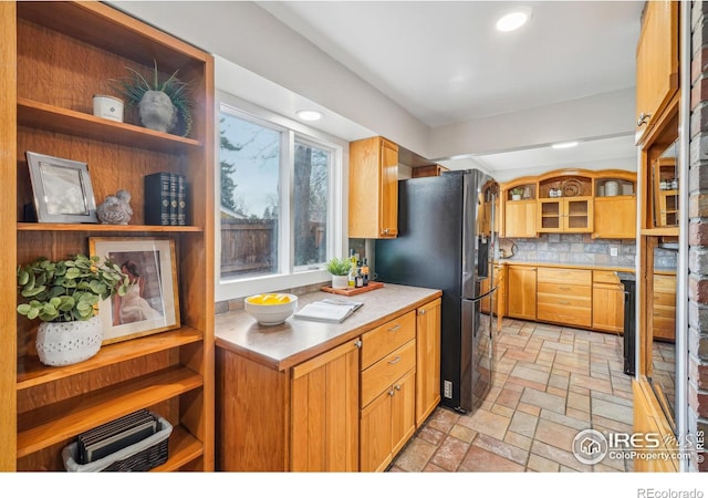 kitchen with backsplash and stainless steel refrigerator