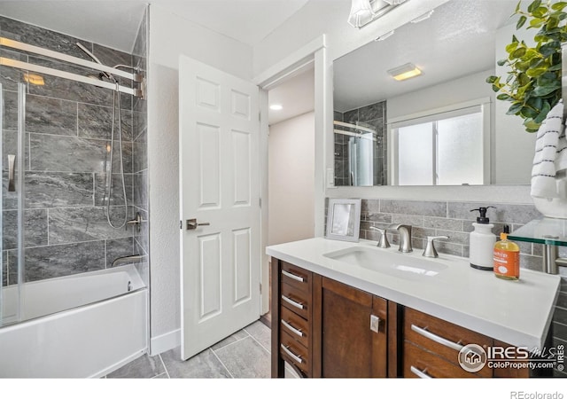 bathroom featuring tasteful backsplash, vanity, and combined bath / shower with glass door