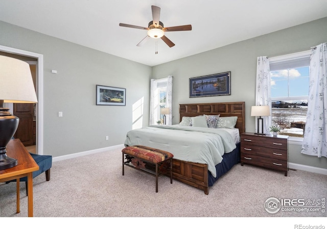 bedroom featuring multiple windows, light colored carpet, and ceiling fan