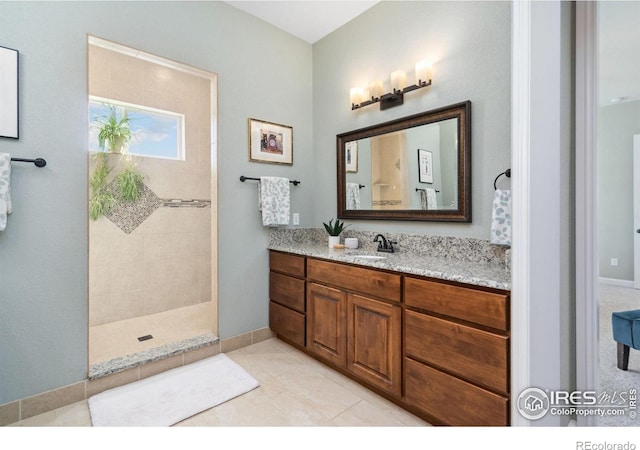 bathroom featuring tile patterned flooring, vanity, and walk in shower