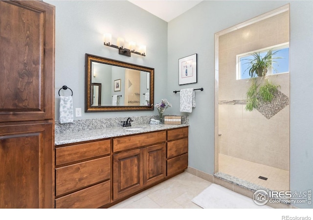 bathroom featuring vanity, tile patterned flooring, and a shower