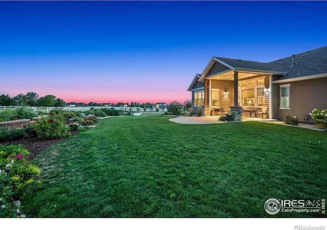 yard at dusk featuring a patio area