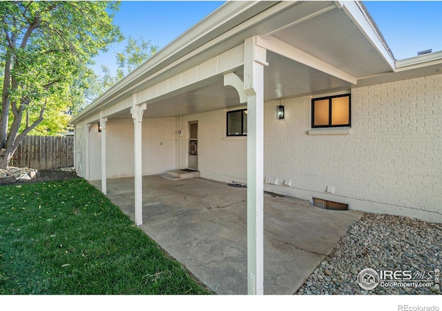 view of patio featuring a carport and fence