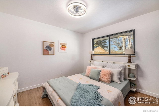 bedroom featuring baseboards and wood finished floors