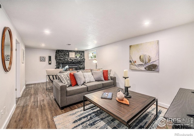 living room with wood finished floors, recessed lighting, a fireplace, and baseboards