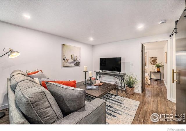 living room with wood-type flooring and a textured ceiling