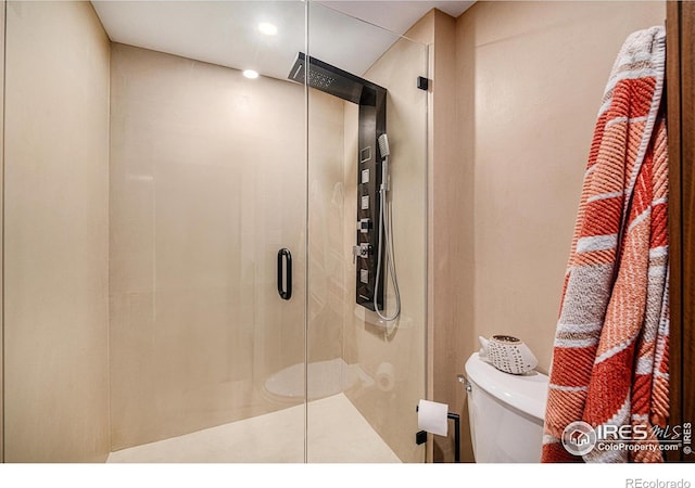 bathroom with a shower with shower door and toilet