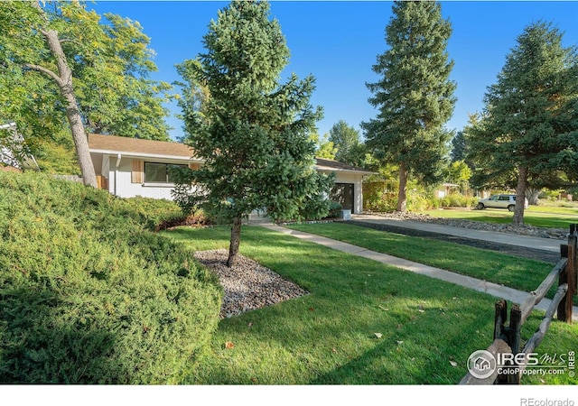 view of front of home with a front yard, a garage, and driveway