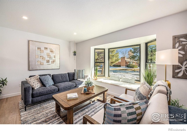 living area with plenty of natural light, recessed lighting, baseboards, and wood finished floors