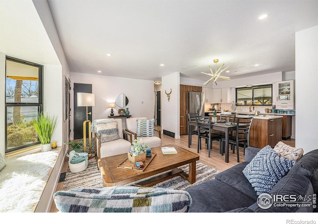 living room with a chandelier and light hardwood / wood-style floors